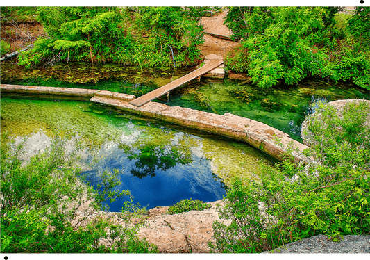Jacob's Well depicted in a high-quality wooden jigsaw puzzle by Wimberley Puzzle Company, available in 250, 500, or 1000 pieces for a unique puzzling experience.